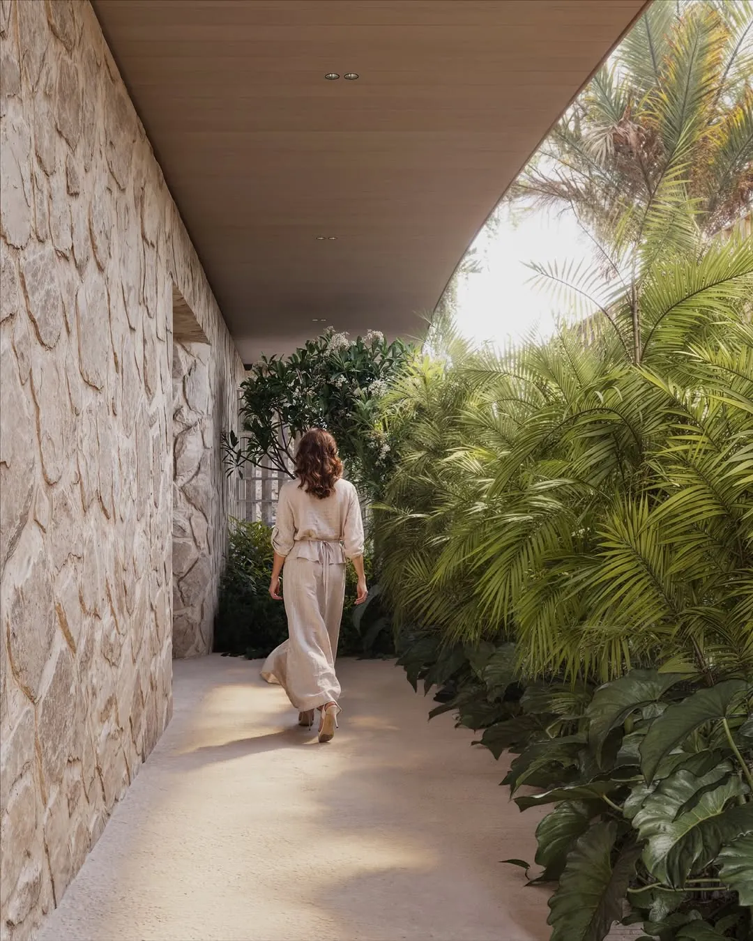 Mockingbird House: passagem em pedra, vegetação e luz natural